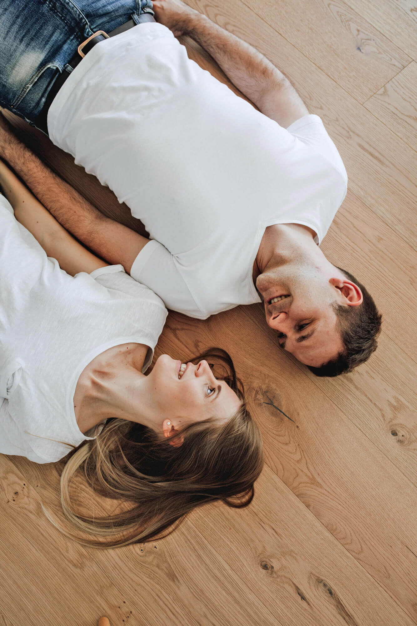 Mann und Frau liegen auf Parkettboden