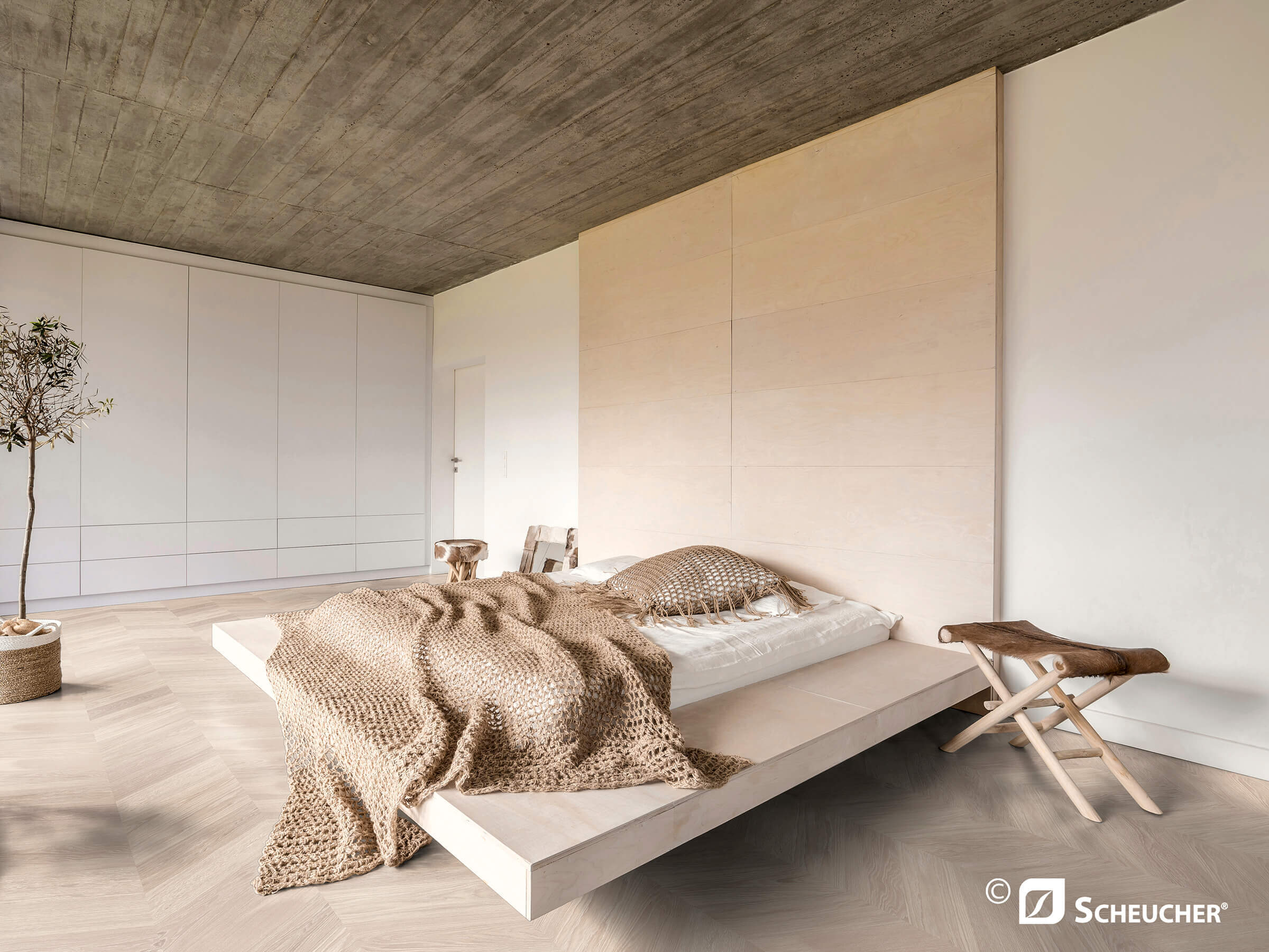 Moderner Innenraum mit Bett und Fischgrät-Parkettboden