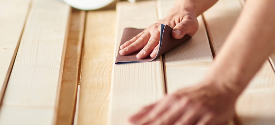 Männerhände arbeiten an Holzlatten